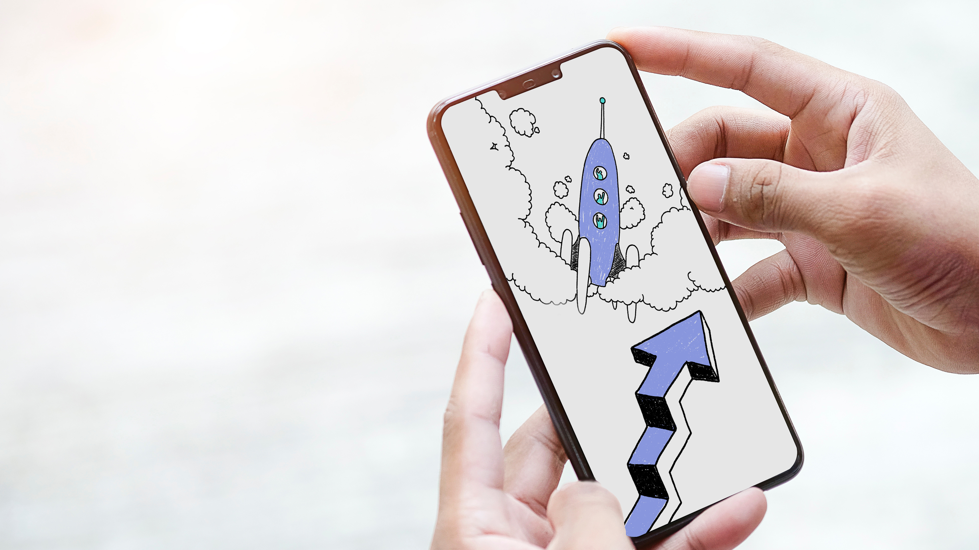 Photo de mains tenant un téléphone dont l'écran affiche une illustration d'une fusée et d'une flêche en forme d'escalier