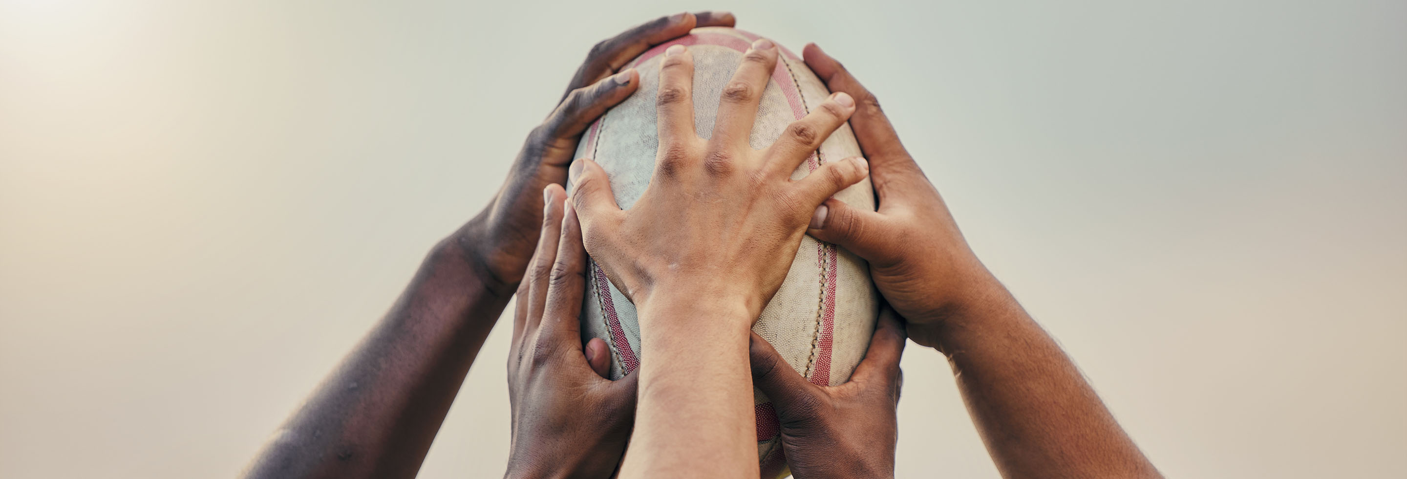 Hands grabbing rugby ball