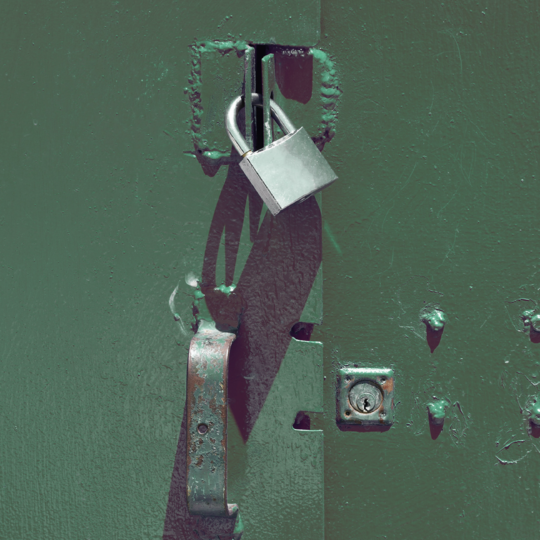 A padlock on a green door
